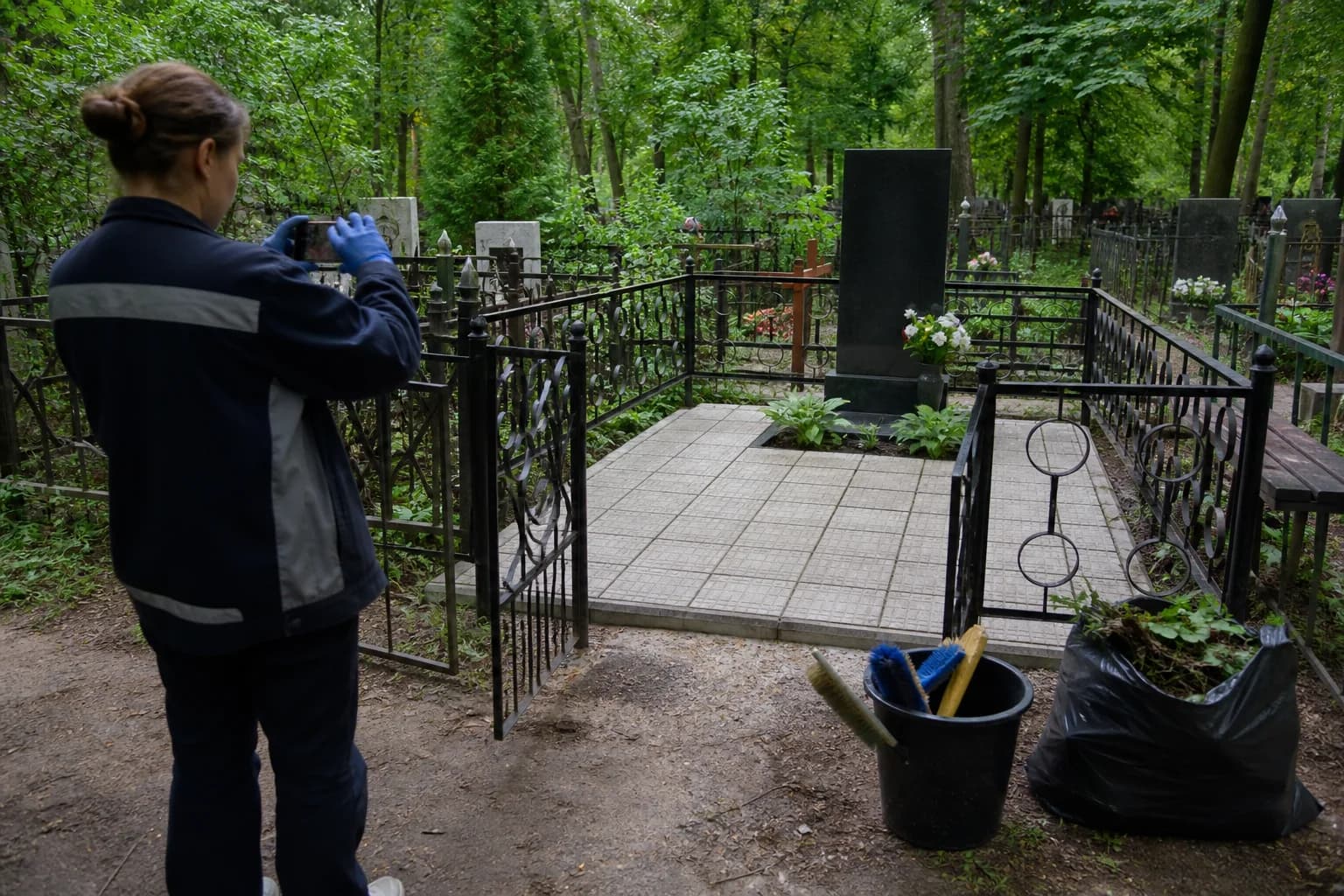 Исполнитель аккуратно убирает участок захоронения по согласованному заданию